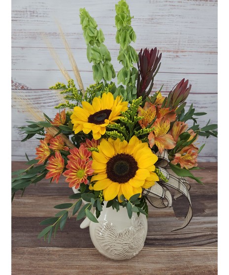 Bells of Ireland, sunflowers, safari sunset, and alstroemeria in a ceramic pitcher with an embossed turkey.